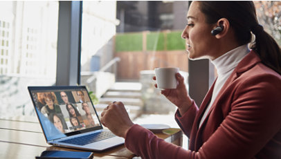 Eine Frau nippt an einer Tasse Tee und nimmt an einem Microsoft Teams-Anruf mit ihren Kolleginnen und Kollegen teil.