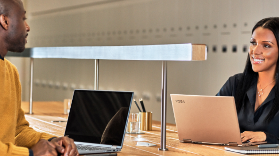 Two people with laptops having a conversation