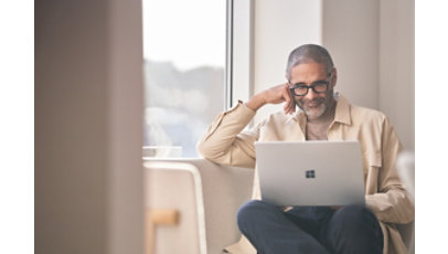 Man using his Surface laptop on a couch.